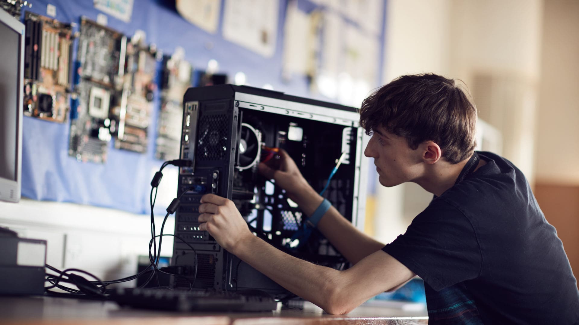 暗网福利 student focusing on fixing a computer on an IT course